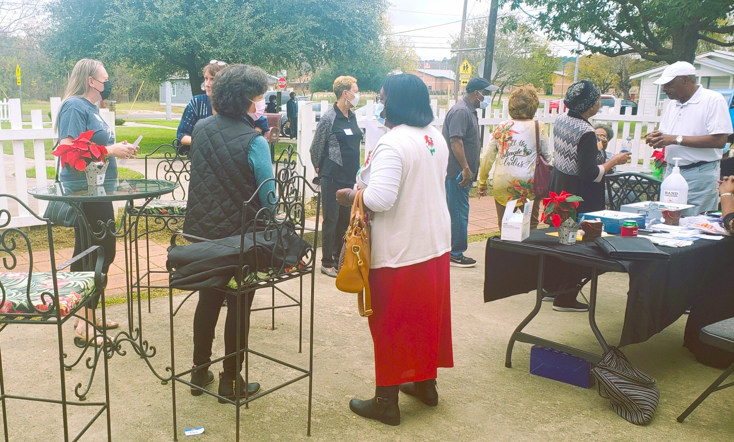 Outdoor community gathering with people and tables