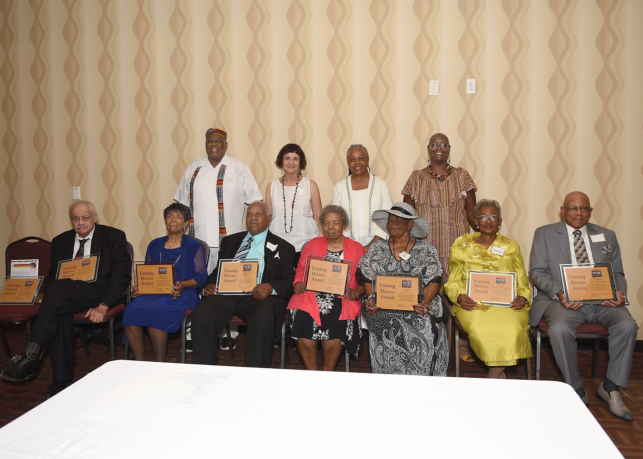 Group of seniors holding award plaques