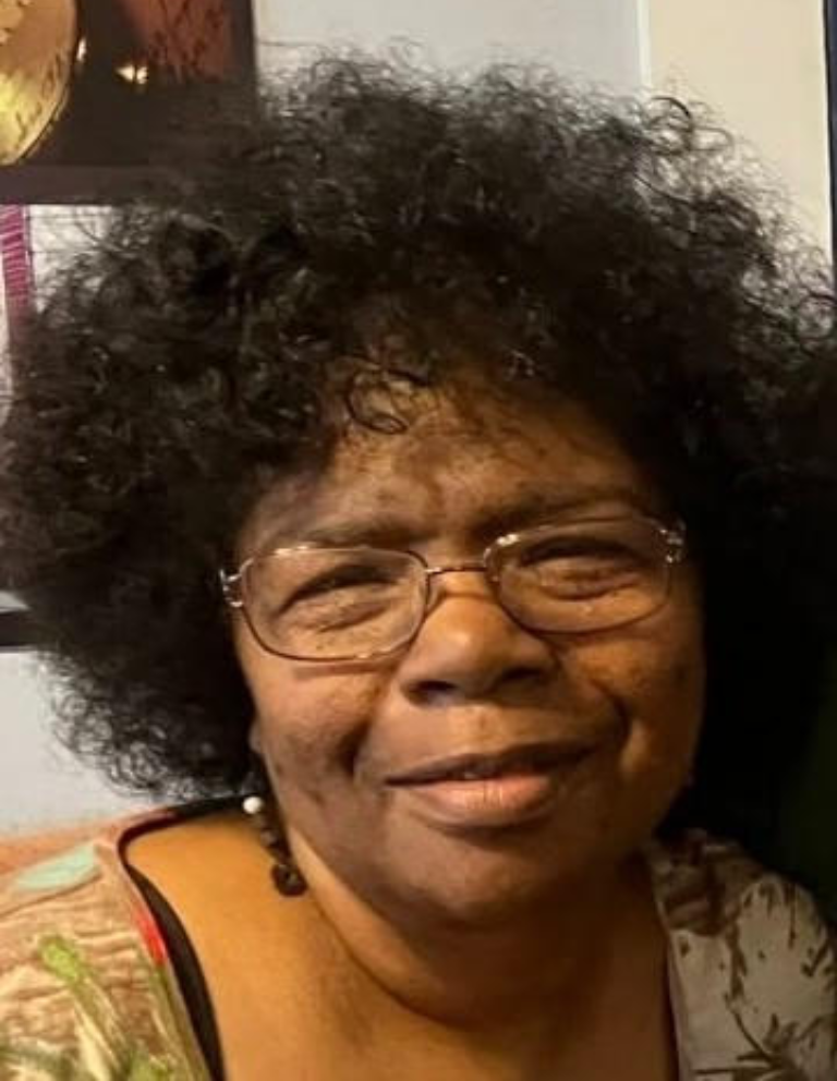 Smiling person with glasses and curly hair